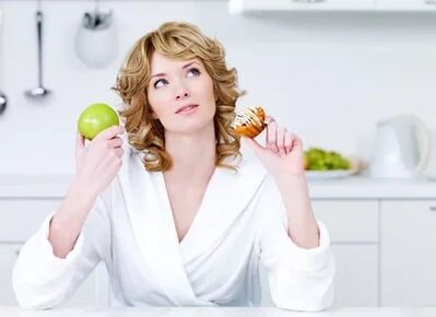 Das Mädchen wählt zwischen Apfel und Kuchen