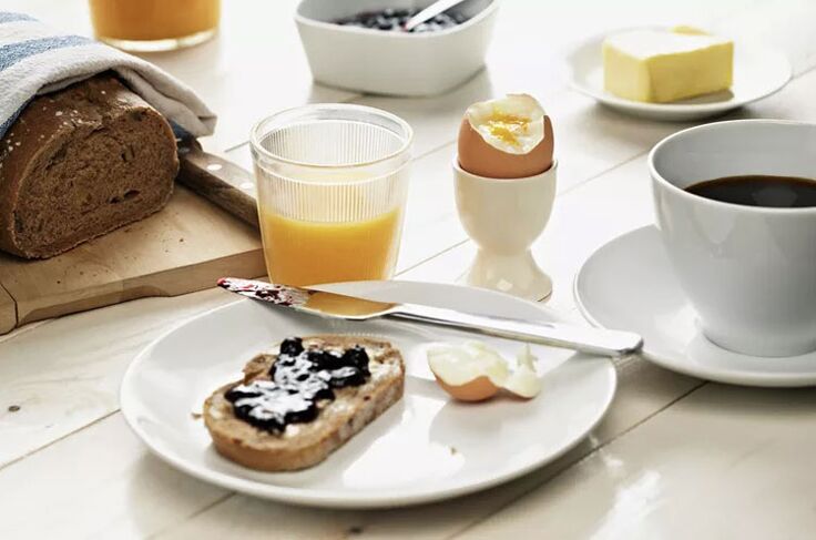 Vollkorntoast, ein Ei und eine Tasse Kaffee zum Frühstück auf einem 1500-Kalorien-Diätmenü